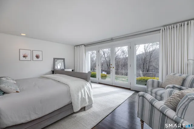 a bedroom with a bed and a large window