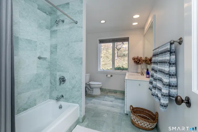 a bathroom with a bathtub a toilet and a shower