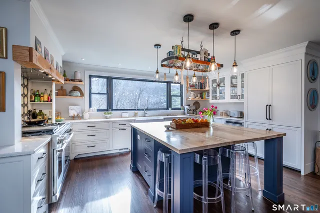 a kitchen that has a lot of cabinets in it and wooden floors