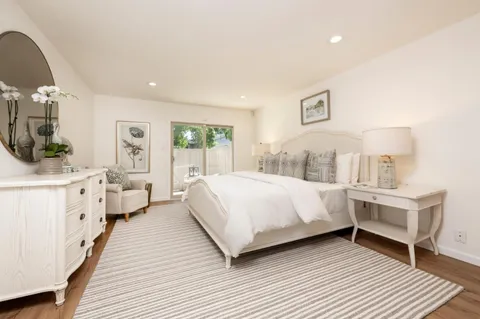 a large bedroom with a bed and wooden floor