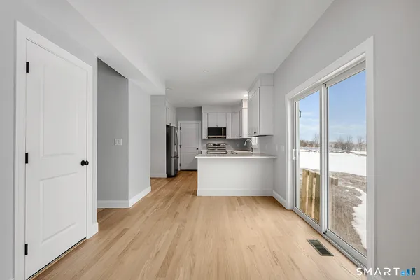 a kitchen with stainless steel appliances a refrigerator and wooden floor