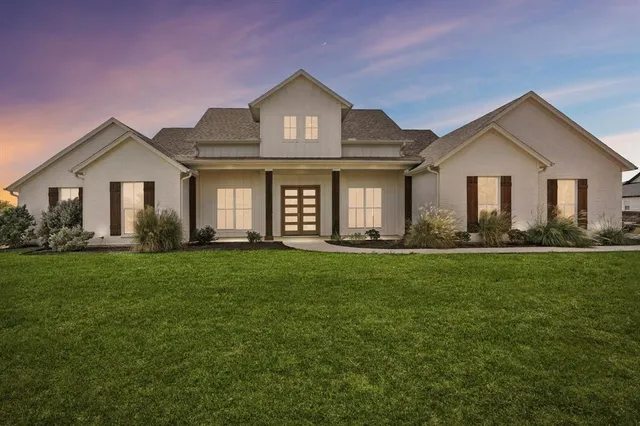 a front view of a house with a yard and trees