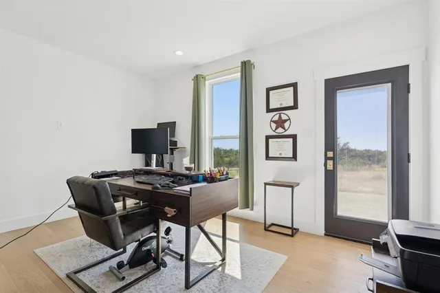 a view of a workspace with furniture and a window