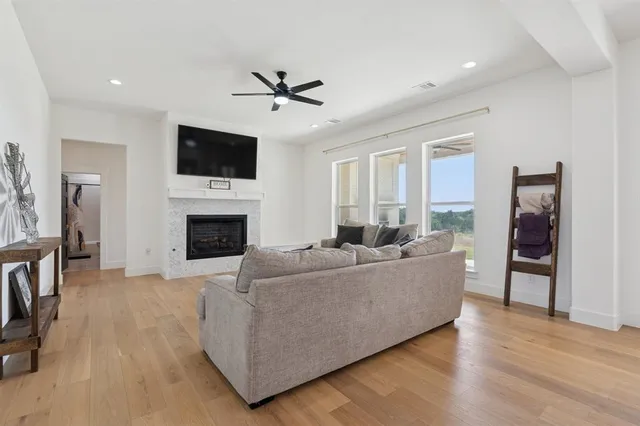 a living room with furniture a flat screen tv and a fireplace