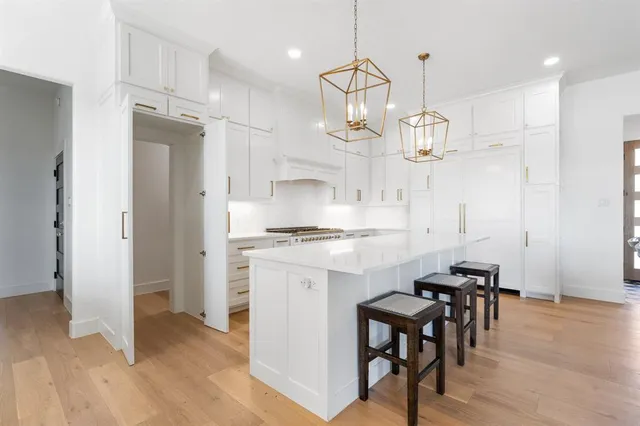 a kitchen with stainless steel appliances kitchen island a chandelier and refrigerator