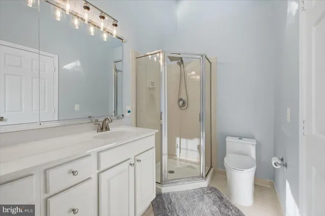 a en suite bathroom with a granite countertop sink toilet and shower