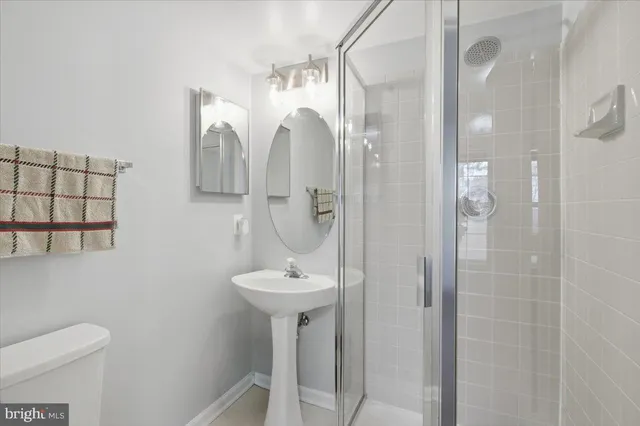 a bathroom with a shower sink and mirror