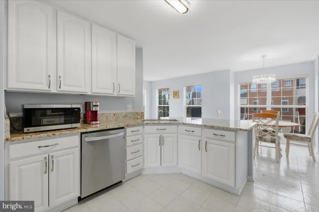 a kitchen with white cabinets and sink
