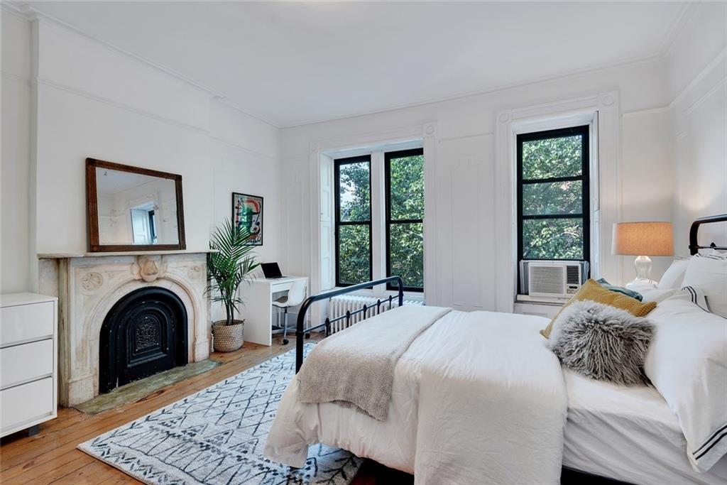 368 5th Street Brooklyn, NY 11215 - Photo 7 of 15 a bedroom with a bed a fireplace and a large window