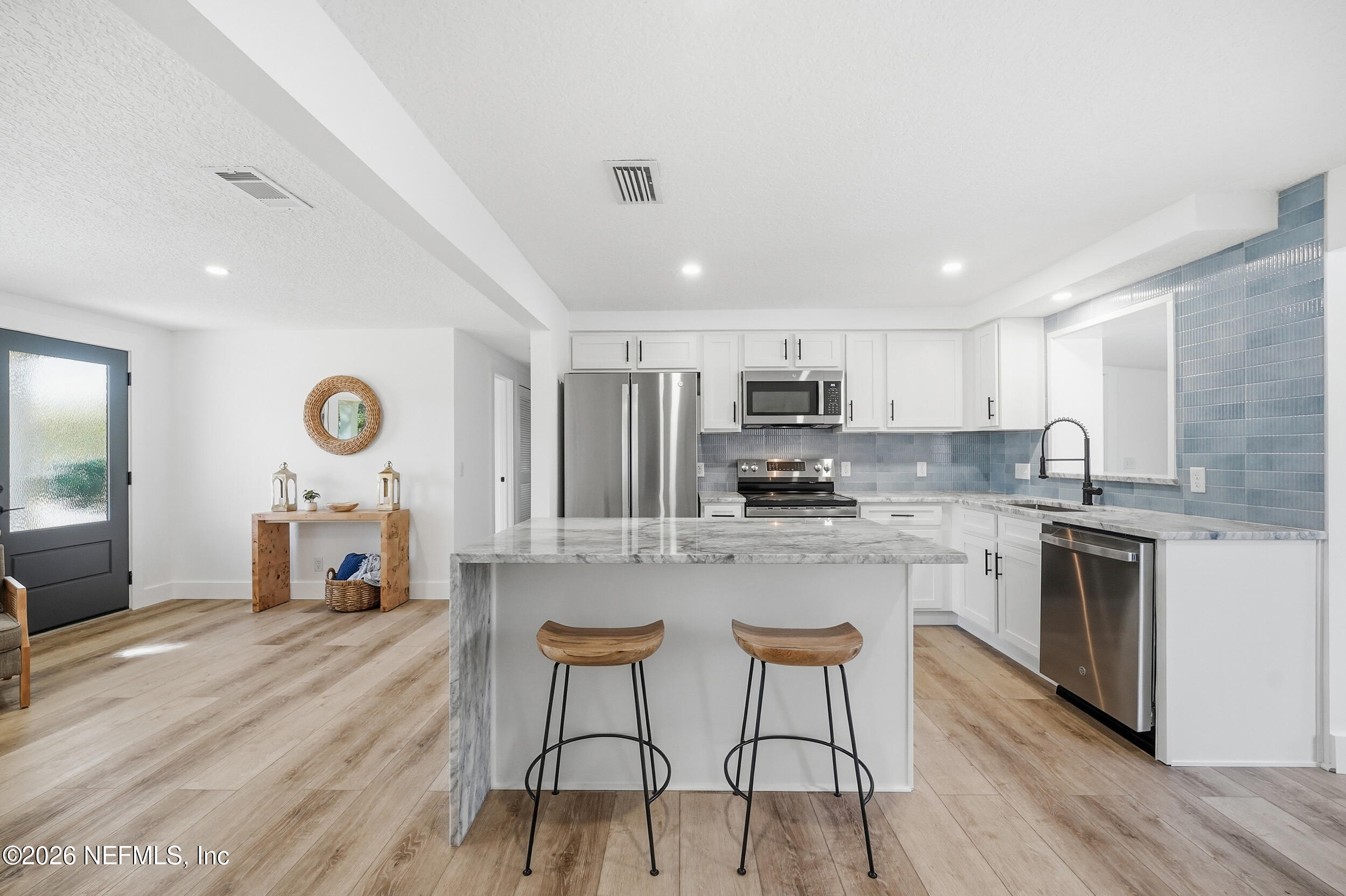 785 Triton Road Atlantic Beach, FL 32233 - Photo 11 of 54 a large kitchen with cabinets a sink a stove a dining table and chairs