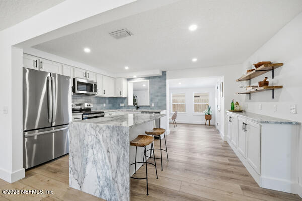 785 Triton Road Atlantic Beach, FL 32233 - Photo 8 of 54 a kitchen with stainless steel appliances granite countertop a refrigerator a stove top oven a sink dishwasher and white cabinets with wooden floor