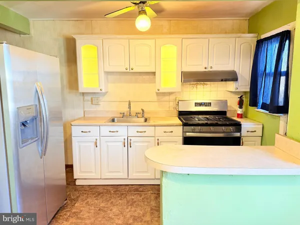 a kitchen with stainless steel appliances a stove a sink and a refrigerator