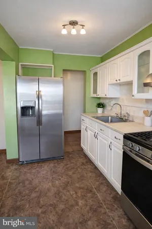 a kitchen with granite countertop a refrigerator and a stove top oven
