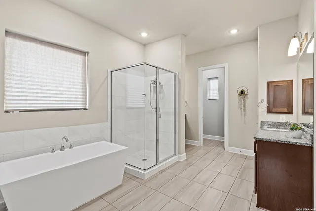 a spacious bathroom with a bathtub sink and mirror