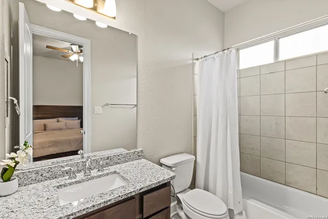 a bathroom with a granite countertop sink toilet and shower