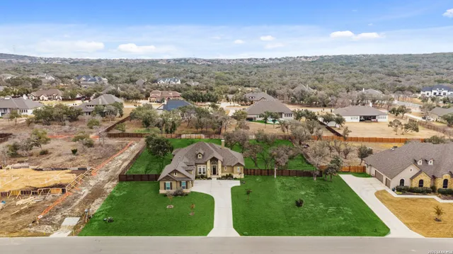 an aerial view of residential houses with outdoor space and trees