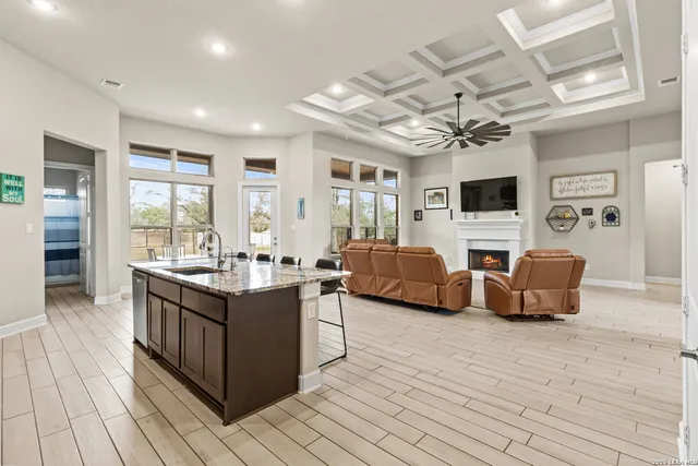 a large living room with stainless steel appliances granite countertop lots of counter top a couch and a flat screen tv