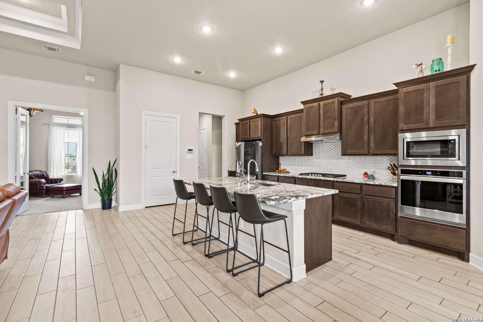 527 James Way Castroville, TX 78009 - Photo 8 of 32 a kitchen with stainless steel appliances a stove a sink dishwasher a refrigerator and a oven with wooden floor