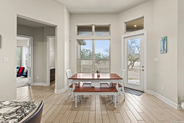 a dining room with wooden floor and large window