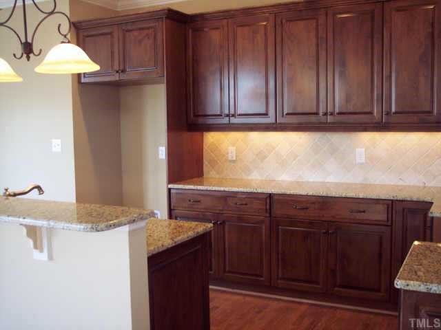 1328 Ileagnes Road Raleigh, NC 27603 - Photo 10 of 12 a kitchen with stainless steel appliances granite countertop wooden cabinets a sink and dishwasher