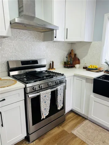a kitchen with a stove and white cabinets