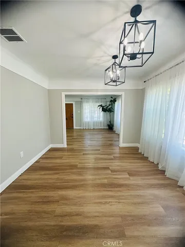 a big room with wooden floor and windows