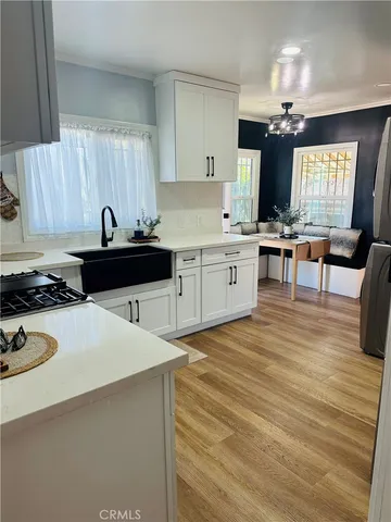 a view of an empty room with wooden floor and a ceiling fan