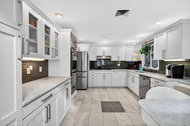 a bedroom with a bed a dresser and flat screen tv