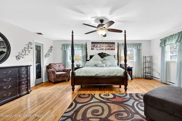 a bedroom with a bed and a flat tv screen on dresser