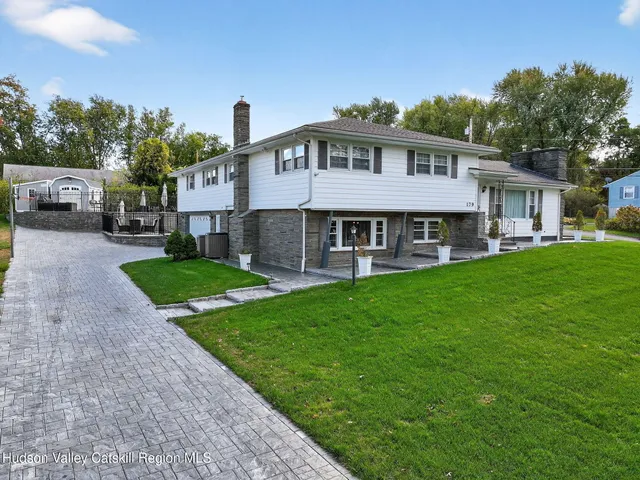 a view of a house with a yard and sitting area