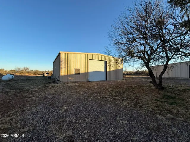 a view of a house with backyard and a tree