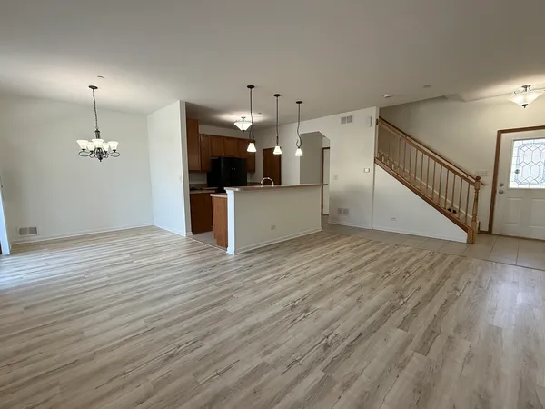 a view of a room with wooden floor and kitchen view