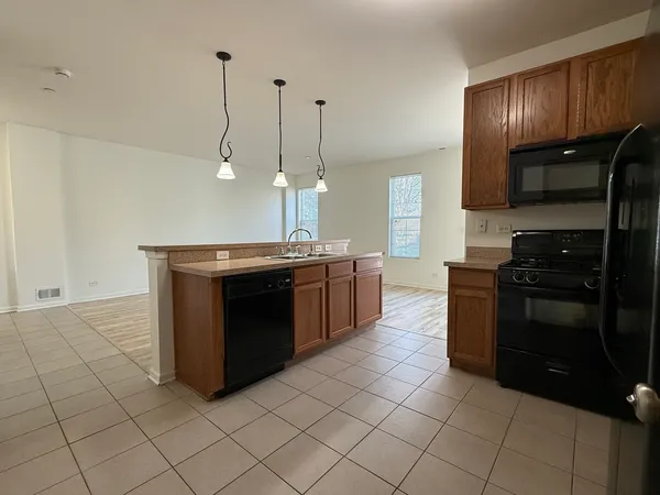 a kitchen with stainless steel appliances granite countertop a stove a sink and a refrigerator