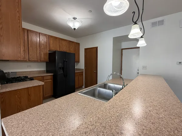 a kitchen with stainless steel appliances granite countertop a sink a refrigerator and a stove