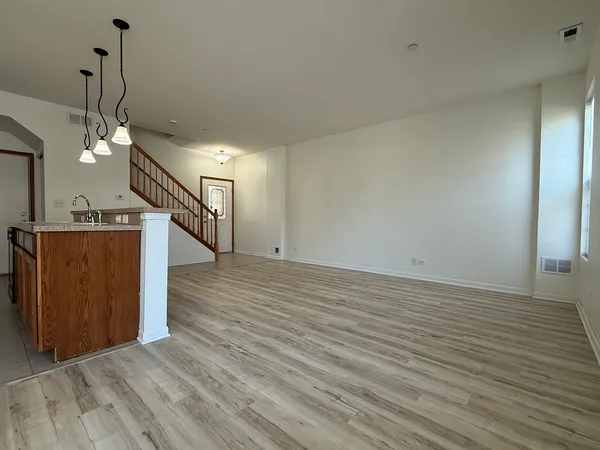 a view of a livingroom with a kitchen counter tops and wooden floor