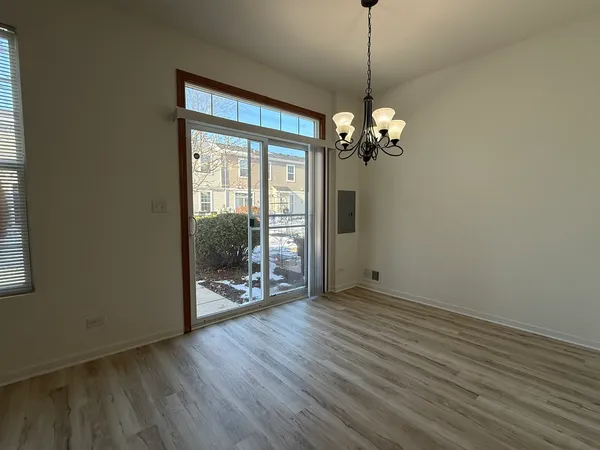 a view of a room with wooden floor staircase and a chandelier