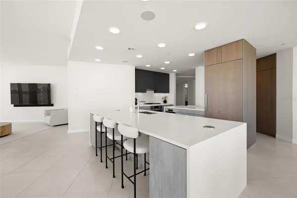 a white kitchen with wooden cabinets a stove a sink and a refrigerator
