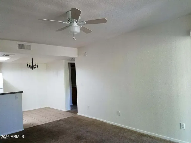 an empty room with closet and fan