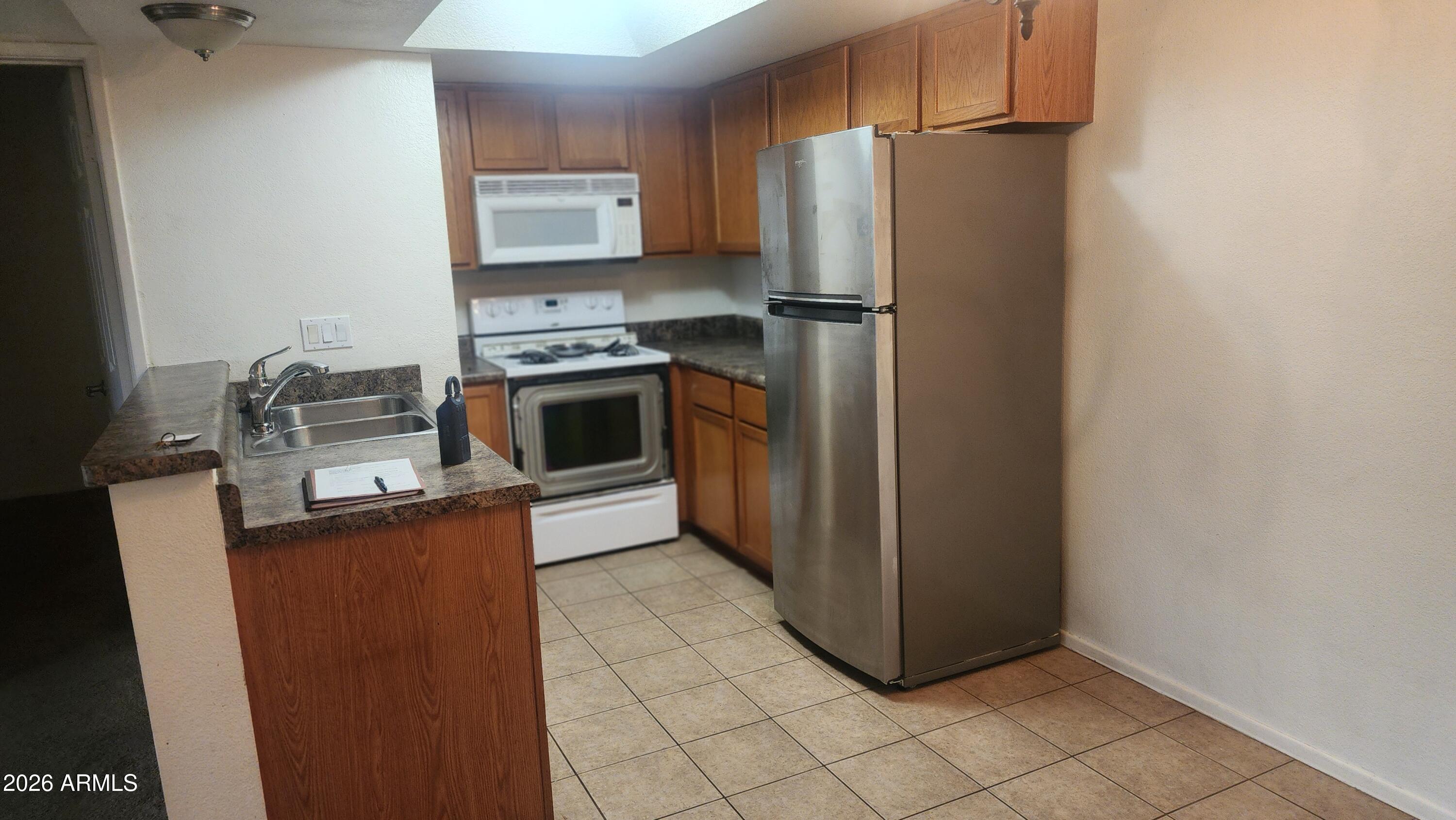 1720 East Thunderbird Road, Unit 2100 Phoenix, AZ 85022 - Photo 3 of 9 a kitchen with stainless steel appliances granite countertop a refrigerator a stove a sink and dishwasher