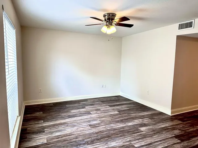 a view of a room with wooden floor and a window