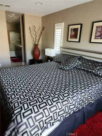 a bedroom with a bed and painting on the wall