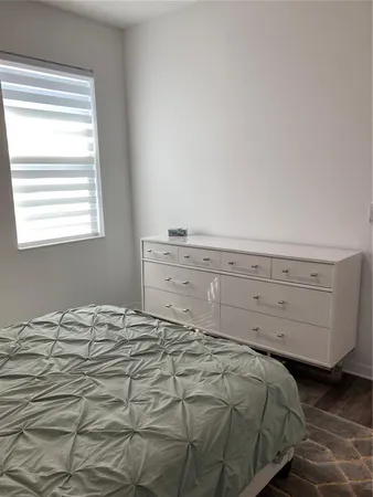 a bed sitting in a bedroom next to a window