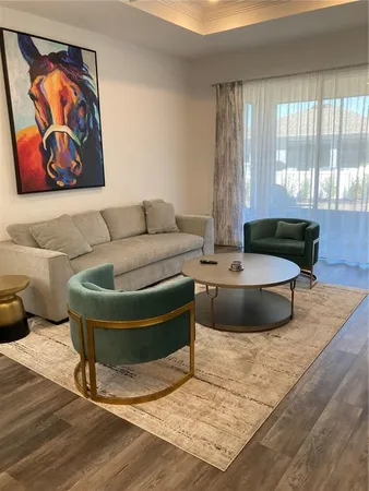 a living room with furniture and a painting on the wall