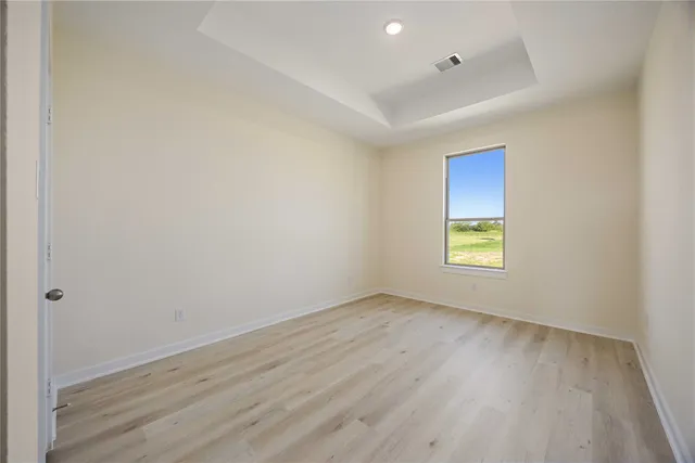 an empty room with a window and wooden floor