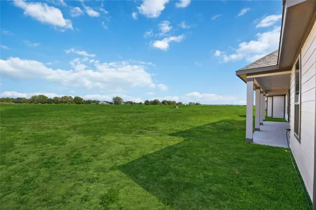 a view of a house with a yard and sitting area