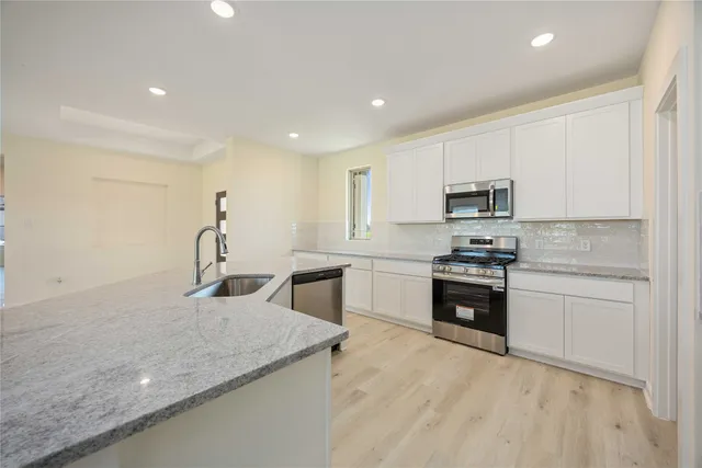 a kitchen with appliances a sink and cabinets