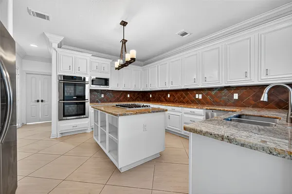 a kitchen with stainless steel appliances granite countertop a stove and a refrigerator