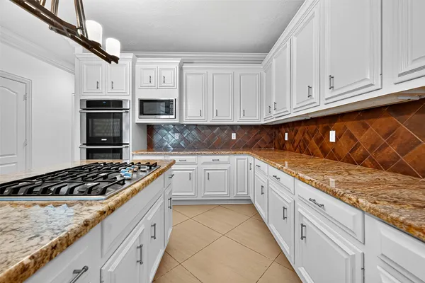 a kitchen with granite countertop a stove sink and cabinets
