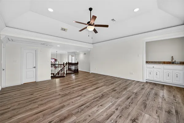 a view of a room with wooden floor and ceiling fan