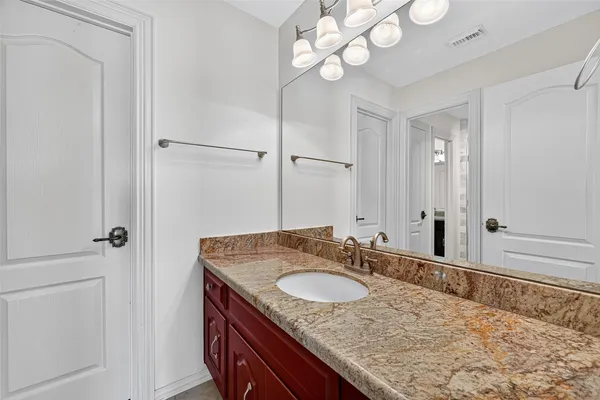 a bathroom with a granite countertop sink and a mirror